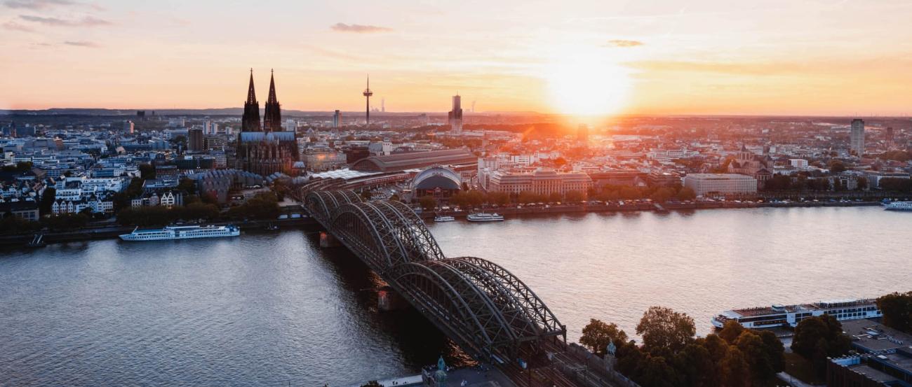 Sonnenuntergang fotografiert von der linken Rheinseite. Man sieht den Kölner Dom und die Hohenzollernbrücke.