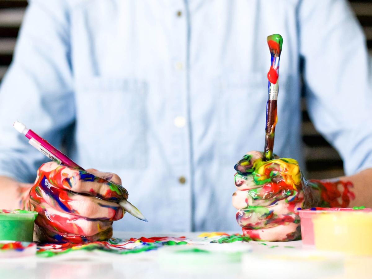 Kreative Person mit Händen voller Farbe