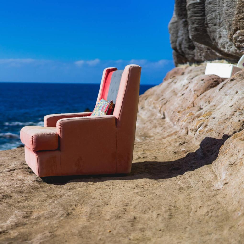 Ein einsamer Sessel steht am Meer